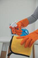 Woman cleaning table using rag and diffuser at home. photo