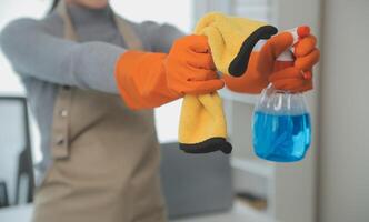 Woman cleaning table using rag and diffuser at home. photo