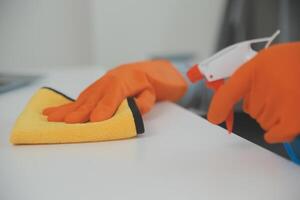 Woman cleaning table using rag and diffuser at home. photo