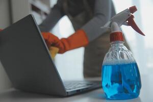 Woman cleaning table using rag and diffuser at home. photo