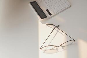 Desk with laptop, eye glasses, earphone, pen and a cup of coffee. Top view with copy space. photo