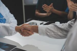 Doctor handshake and partnership in healthcare, medicine or trust for collaboration, unity or support.Team of medical experts shaking hands in teamwork for or success in hospital photo