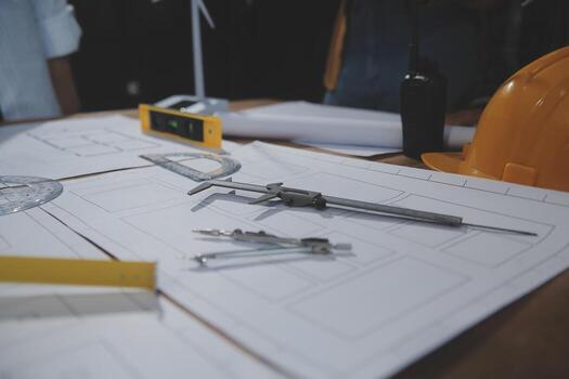 Team of multiethnic architects working on construction plans in meeting room. Engineers discussing on project in office. Mature businessman and woman standing around table working on blueprint. photo