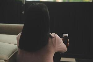 Depressed woman sitting alone on the bed with hands on head feel stress, sad and worried in the dark bedroom and low light environment photo