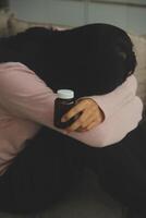 Depressed woman sitting alone on the bed with hands on head feel stress, sad and worried in the dark bedroom and low light environment photo
