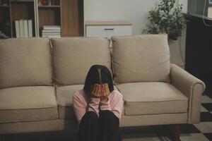 Depressed woman sitting alone on the bed with hands on head feel stress, sad and worried in the dark bedroom and low light environment photo