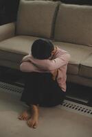 Depressed woman sitting alone on the bed with hands on head feel stress, sad and worried in the dark bedroom and low light environment photo