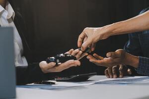 Car sales representative gives keys to new car owner, concept for car rental Focus on the key. Pick up the key. Close-up of the key transfer from the new machine to the buyer. photo