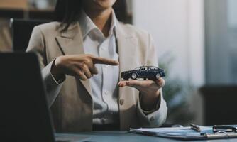 Business car rental company service, Close up hand of agent dealer giving, holding car key to customer renter, new owner after signed rental, purchase contract in document, vehicle sales agreement. photo