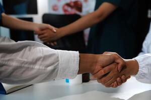 Doctor handshake and partnership in healthcare, medicine or trust for collaboration, unity or support.Team of medical experts shaking hands in teamwork for or success in hospital photo