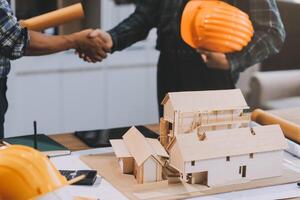 Architect and construction engineer holding hands while working for teamwork and cooperation concept after completing an agreement at construction site, office, close-up image photo