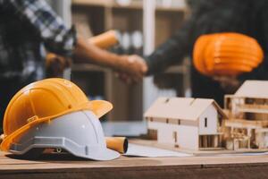 Architect and construction engineer holding hands while working for teamwork and cooperation concept after completing an agreement at construction site, office, close-up image photo