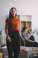 Family couple ignoring each other after a quarrel. Two people turn away and don't talk to each other. Angry young man and woman sitting back to back, with arms crossed on the sofa in the living room photo