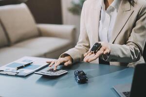 Business car rental company service, Close up hand of agent dealer giving, holding car key to customer renter, new owner after signed rental, purchase contract in document, vehicle sales agreement. photo