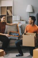 Asian couple, husband and attractive wife are happiness and are helping each other lose things into boxes, To prepare to move to a new home, concept to family and relocation photo