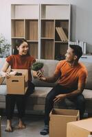 Asian couple, husband and attractive wife are happiness and are helping each other lose things into boxes, To prepare to move to a new home, concept to family and relocation photo