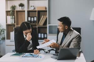 Manager is hard talking with employee in an office. Businessmen arguing at workplace, disagreeing over document, partners having conflict while negotiating, business deal failure photo