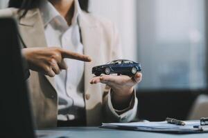 Business car rental company service, Close up hand of agent dealer giving, holding car key to customer renter, new owner after signed rental, purchase contract in document, vehicle sales agreement. photo