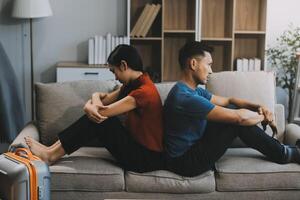 Man and woman sitting on sofa in quarrel, not talking to each other. Concept of relationship problems photo