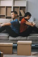 Man and woman sitting on sofa in quarrel, not talking to each other. Concept of relationship problems photo