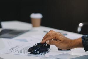 Car sales representative gives keys to new car owner, concept for car rental Focus on the key. Pick up the key. Close-up of the key transfer from the new machine to the buyer. photo