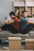 Man and woman sitting on sofa in quarrel, not talking to each other. Concept of relationship problems photo