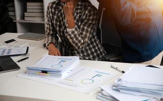 Group of confident business people point to graphs and charts to analyze market data, balance sheet, account, net profit to plan new sales strategies to increase production capacity. photo