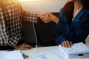 Group of confident business people point to graphs and charts to analyze market data, balance sheet, account, net profit to plan new sales strategies to increase production capacity. photo
