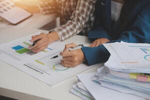 Group of confident business people point to graphs and charts to analyze market data, balance sheet, account, net profit to plan new sales strategies to increase production capacity. photo