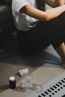 Cold medicine and sick woman drinking hot beverage to get well from flu, fever and virus. Dirty paper towels and tissues on table. Ill person wearing warm woolen stocking socks in winter. photo