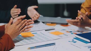 A group of cheerful Asian graphic designers or developers is standing in the meeting, clapping their hands, and celebrating their successful project in the meeting together. video