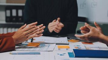 A group of cheerful Asian graphic designers or developers is standing in the meeting, clapping their hands, and celebrating their successful project in the meeting together. video
