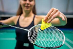 Close up view of racket and shuttlecock, practicing serve before playing in badminton on inside court. High quality photo