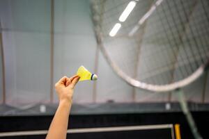 Close up view of racket and shuttlecock, practicing serve before playing in badminton on inside court. High quality photo