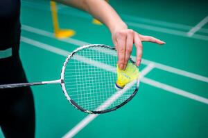 Close up view of racket and shuttlecock, practicing serve before playing in badminton on inside court. High quality photo