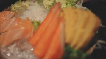 Japans voedsel set. rauw vis Ingepakt in een rood, ronde voorwerp. de reeks bestaat van Zalm, tonijn, krab stokken, zoet ei. video