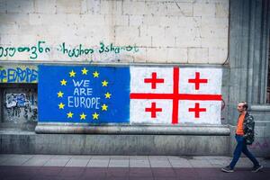 Tbilisi, Georgia - 16th may, 2024- Georgian flag lay on ground by written statement we need EU. Integration process to EU concept photo