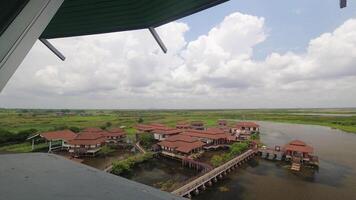 Top view time lapse from Viewpoint tower see the Multipurpose building of park,pathway bridge, pavilion, lotus leaf and water glass in wetland, Thale Noi Waterfowl video