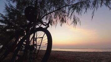 Time lapse bicycle parked on the beach on sunrise with beautiful sea view early morning exercise.Morning sunrise ride on the beach.Healthy lifestyle recreational activities concept video