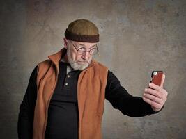 senior man taking selfie with a phone photo