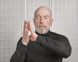 senior man is practicing reflexology therapy photo