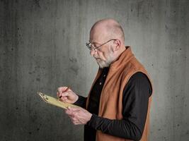 senior man sketching on a clipboard photo