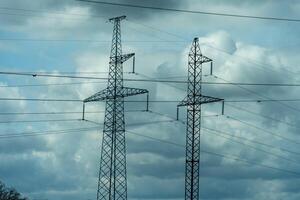 High voltage towers with sky background. Power line support with wires for electricity transmission. High voltage grid tower with wire cable at distribution station. Energy industry, energy saving photo