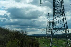 High voltage towers with sky background. Power line support with wires for electricity transmission. High voltage grid tower with wire cable at distribution station. Energy industry, energy saving photo