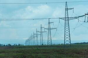 High voltage towers with sky background. Power line support with wires for electricity transmission. High voltage grid tower with wire cable at distribution station. Energy industry, energy saving photo