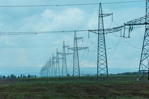 High voltage towers with sky background. Power line support with wires for electricity transmission. High voltage grid tower with wire cable at distribution station. Energy industry, energy saving photo