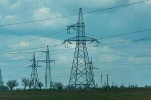 High voltage towers with sky background. Power line support with wires for electricity transmission. High voltage grid tower with wire cable at distribution station. Energy industry, energy saving photo