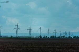 High voltage towers with sky background. Power line support with wires for electricity transmission. High voltage grid tower with wire cable at distribution station. Energy industry, energy saving photo