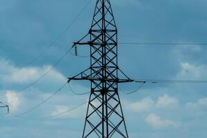 High voltage towers with sky background. Power line support with wires for electricity transmission. High voltage grid tower with wire cable at distribution station. Energy industry, energy saving photo