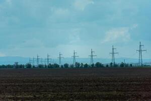 High voltage towers with sky background. Power line support with wires for electricity transmission. High voltage grid tower with wire cable at distribution station. Energy industry, energy saving photo